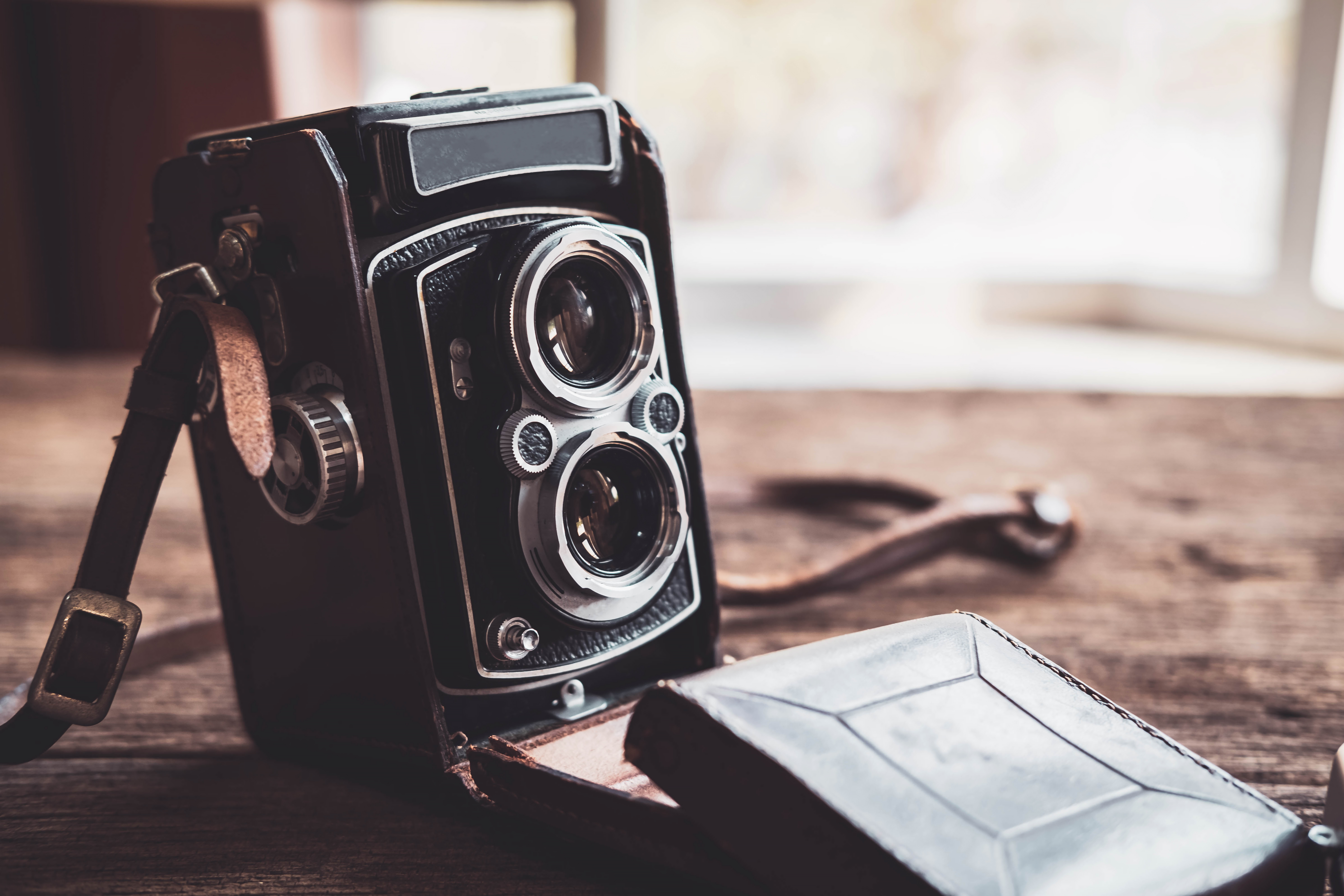 Old retro camera on old wooden background